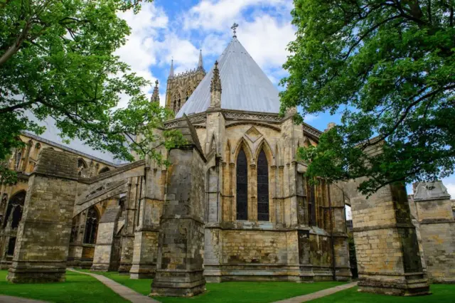 The exterior of Chapter House in the foreground with Lincoln Cathedral in the background