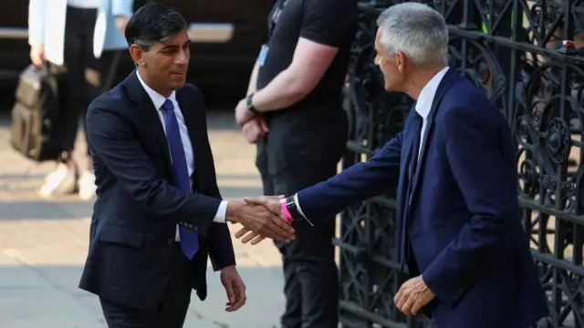 Rishi Sunak arrives at the debate, greeted by Tim Davie