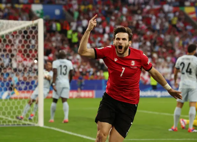 Khvicha Kvaratskhelia puts his arm up in celebration