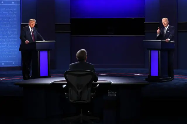 Donald Trump (L) and Joe Biden (R) debate on stage at Case Western University in Ohio in September 2020, as journalist Chris Wallace (C) moderates.