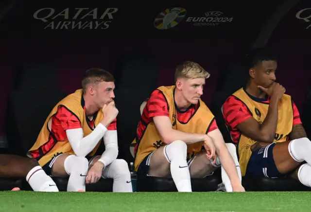 Cole Palmer, Anthony Gordon and Ezri Konsa sit on the bench