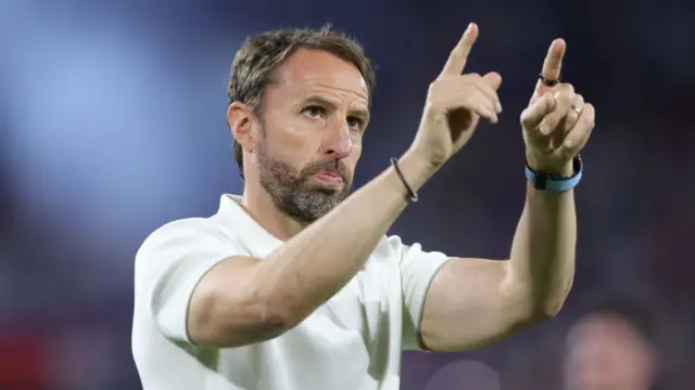 England manager Gareth South gate looks focused.  He is pointing with both hands to people in the crowd.  This is during his sides match against Slovenia at Euro 2024