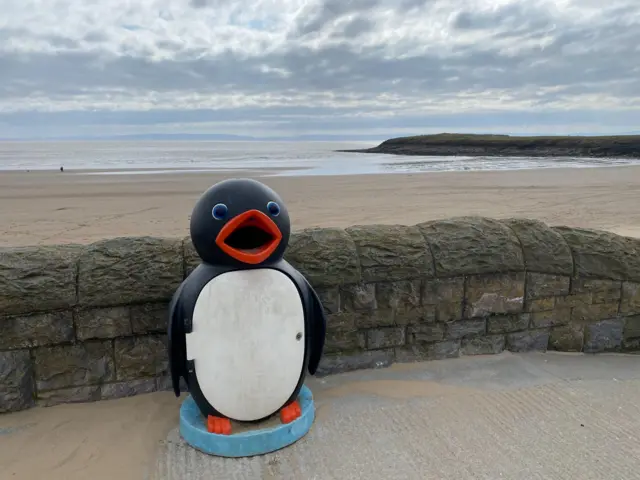 A penguin-shaped bin on Barry Island Beach