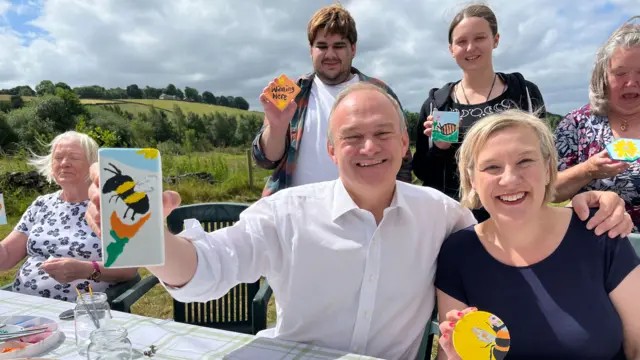 Ed Davey grins in the sunshine as he shows off his pottery