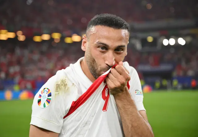 Cenk Tosun kisses the badge on his Turkey shirt