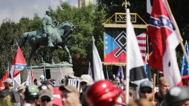 A crowd of protesters around a statue