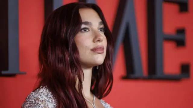 Dua Lipa is seen in close up with the Time logo in the background.