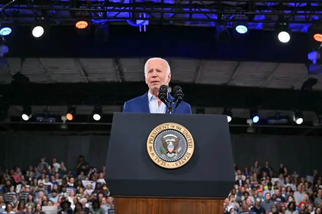 Joe Biden stands in front of a podium