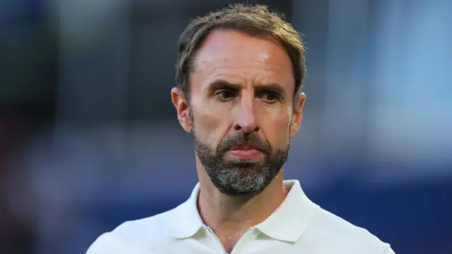 Portrait shot of Gareth Sothgate.  He has a worries glum look on his face during an England match at Euro 2024.  He is wearing a white shirt