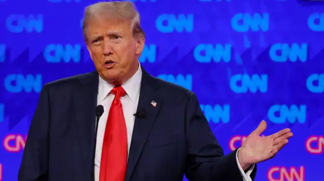 Donald Trump motions with his hand while answering a question during the debate