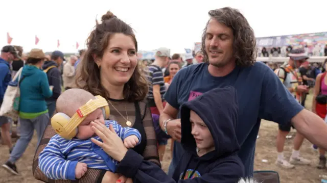 Baby Finlay enjoying his first Glastonbury Festival with mother Rosie, sister Sofia and father Tom