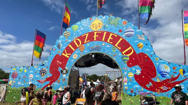 A bright colourful entrance archway with the words KidzField painted across it.