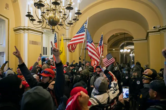 Rioters inside the Capitol building waving US flags