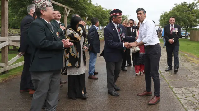 Rishi Sunak shakes the hand of a veteran