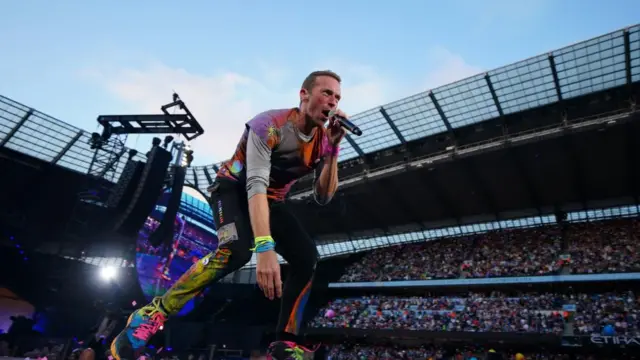 Chris Martin from Coldplay performs in a stadium