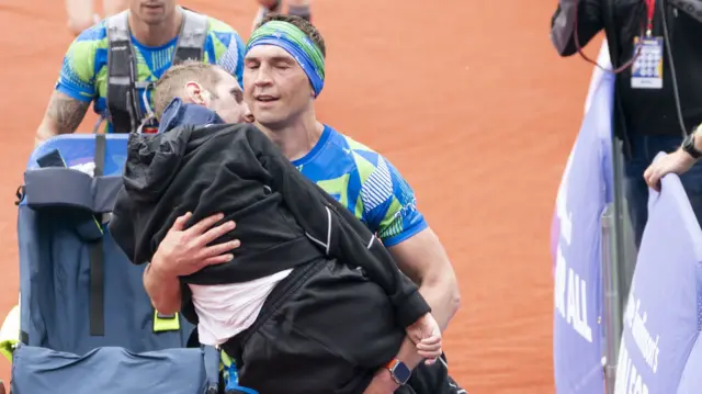 Kevin Sinfield carries Rob Burrow over the finishing line