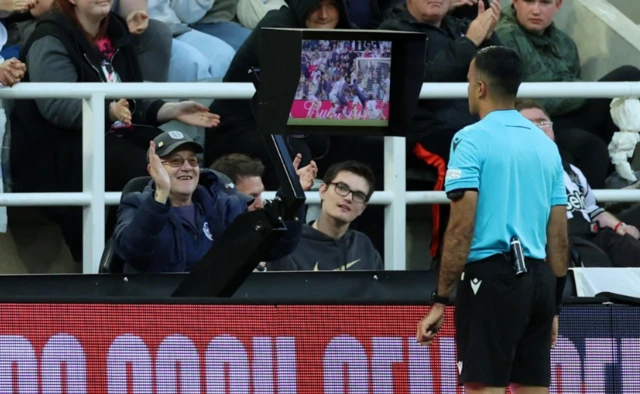 Referee Rohit Saggi looks at the VAR monitor