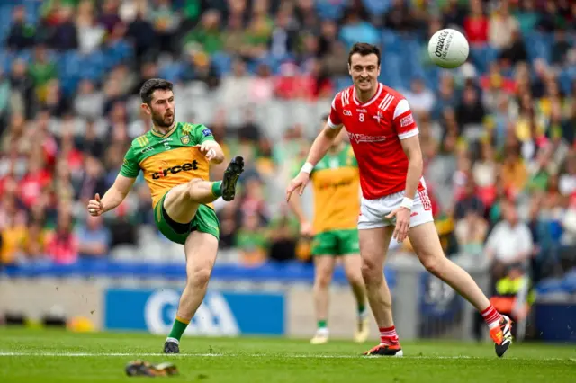 Ryan McHugh of Donegal kicks a point despite the efforts of Tommy Durnin of Louth