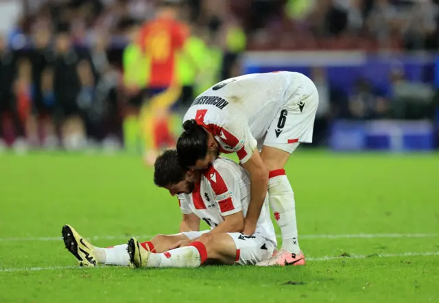 Otar Kiteishvili sits on the floor as Giorgi Kochorashvili stands behind him