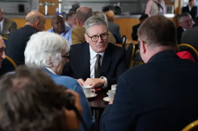 Sir Keir sits at a table with veterans at a coffee morning on the campaign trail