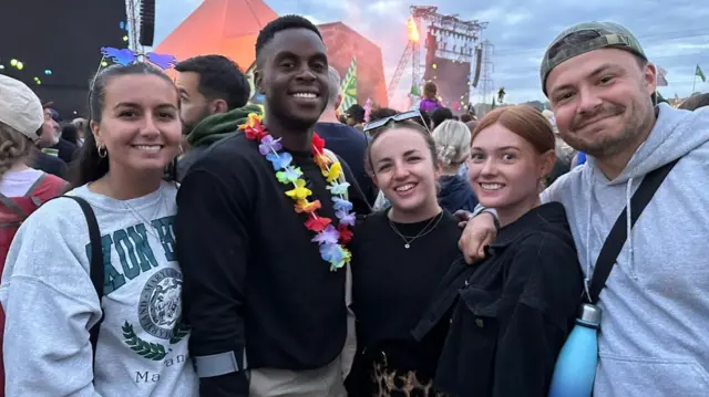 Five people stood in a crowd near the stage