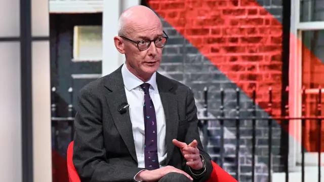 Pat McFadden sitting on a red chair on the set of the Laura Kuenssberg programme