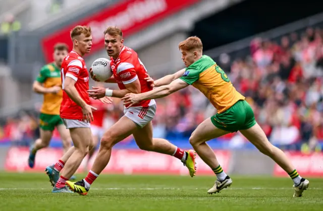 Conor Grimes of Louth in action against Ciaran Moore of Donegal