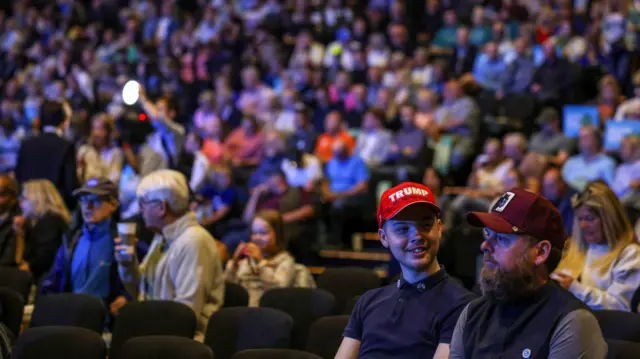 An attendee wearing a Trump cap is seated ahead of the Reform UK party's rally