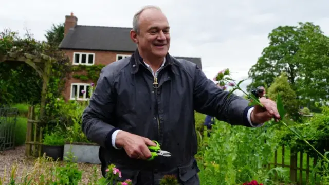 Ed Davey picking flowers