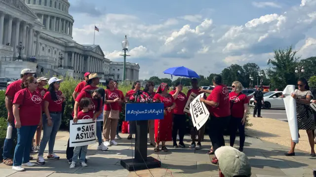 People hold signs outside of Capitol Hill