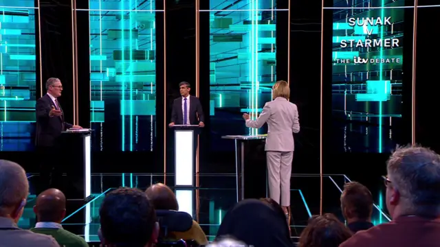 Sunak and Starmer face each other as they face a question from Julie Etchingham