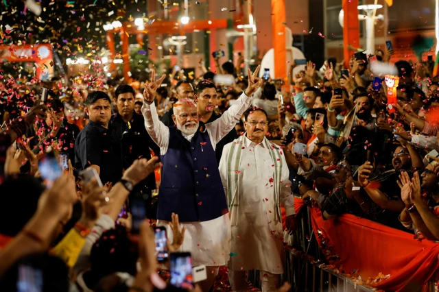 Supporters throw petals on Indian Prime Minister Narendra Modi as he arrives at Bharatiya Janata Party (BJP) headquarters in New Delhi, India,