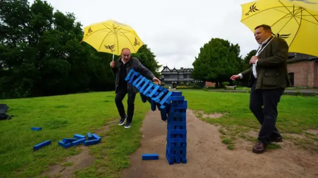 Ed Davey with blue jenga wall