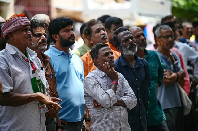 People watch latest vote counting results live on a large screen at the BJP office in Bengaluru