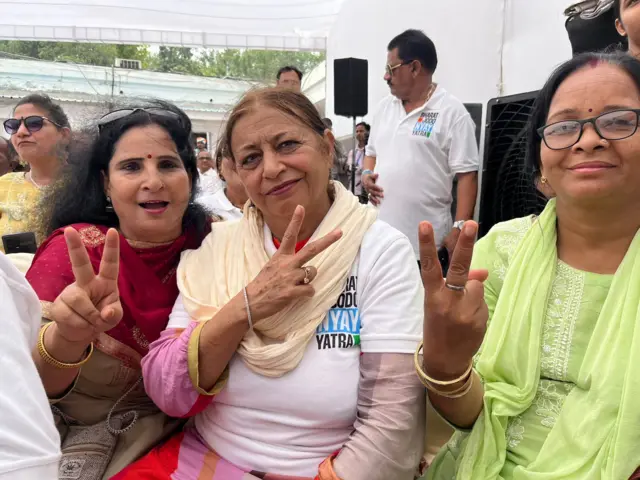 Party workers hold up signs of victory as early trends come in