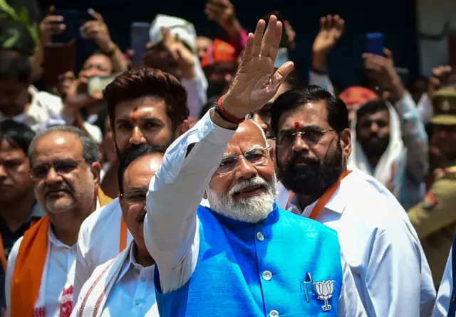 : India's Prime Minister Narendra Modi (C), surrounded by other party leaders and MPs including Home Minister Amit Shah and Uttar Pradesh Chief Minister Yogi Adityanath, greets supporters after filing nomination papers on May 14, 2024 in Varanasi, India.