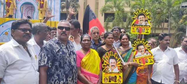 Workers hold up party symbols and posters of MK Stalin, DMK party chief and Tamil Nadu chief minister