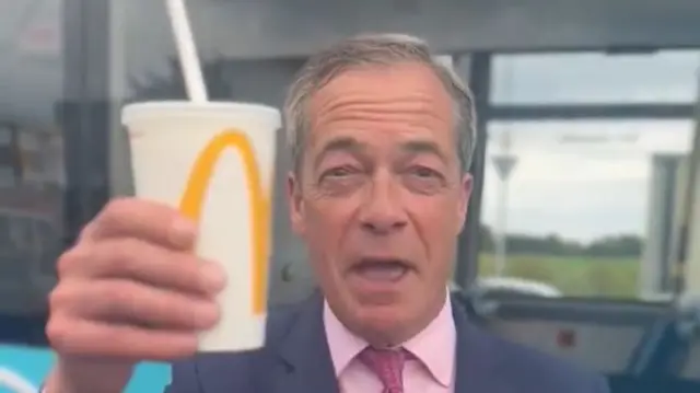 Nigel Farage holding a milkshake