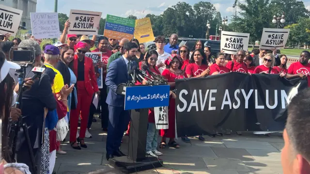 People gather outside Capitol Hill with #saveasylum posters