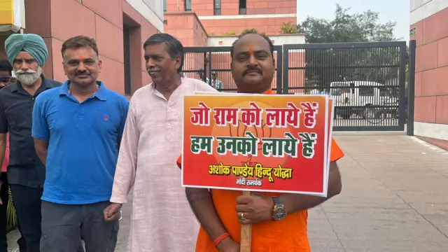 Ashok Pandey holds up a placard saying, 'The one who’s brought Lord Ram, we will bring him'