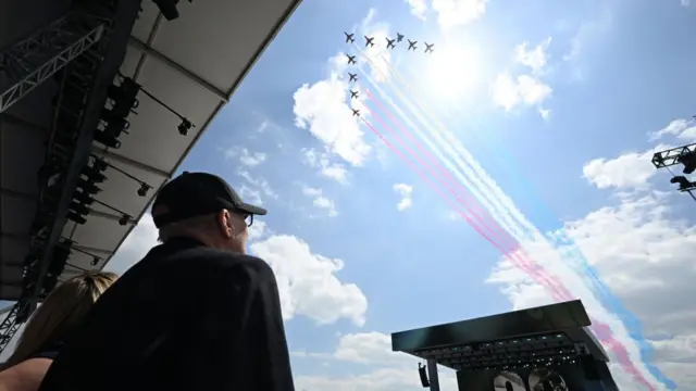 Man looks on as Red Arrows perform flypast