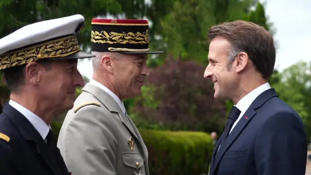 Emmanuel Macron shaking hands with dignitaries at the D-Day event in France