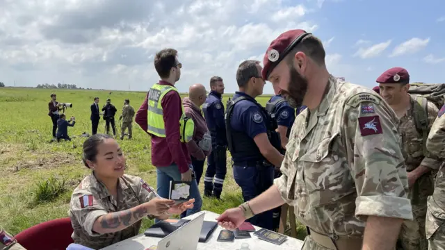 Military personnel check passports