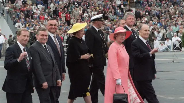 French President François Mitterrand (R) arrives for ceremonies during the commemoration of the 50th anniversary of D-Day 06 June 1994 at Omaha Beach. (From L-R) Czech President Vaclav Havel, Polish President Lech Walesa, non-unidentified, Dutch Queen Beatrix, Norwegian King Harald, Britain's Queen Elizabeth and US President Bill Clinton.