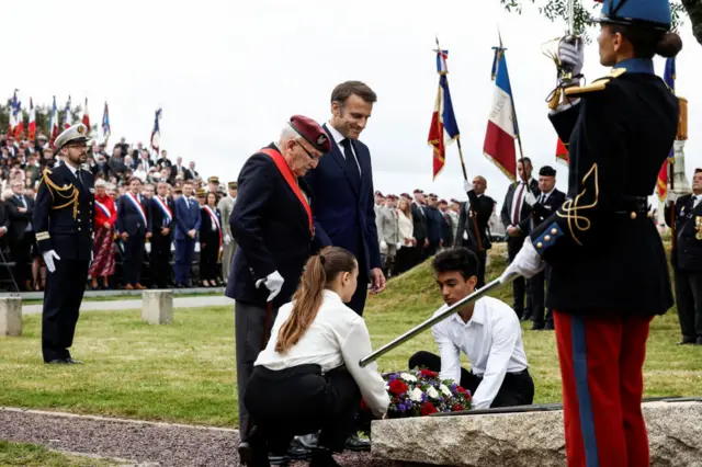 France's President Emmanuel Macron with 98-year-old Achille Muller, the last survivor of the Free French Forces, look on as a wreath is layed during a ceremony commemorating French troops in Brittany