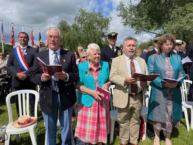 The family of Major John Howard, holding hymn books at the outdoor service