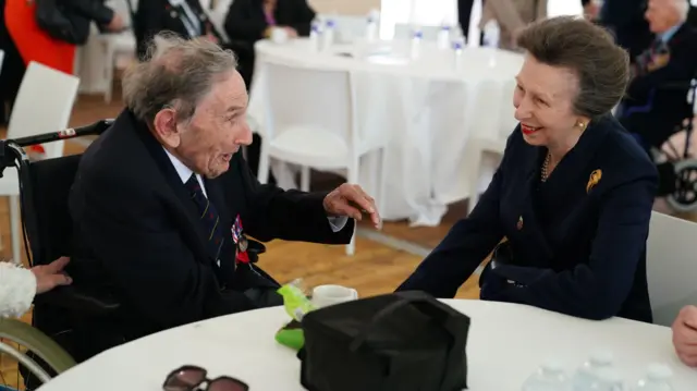 Inside a marquee Princess Anne talks with a veteran