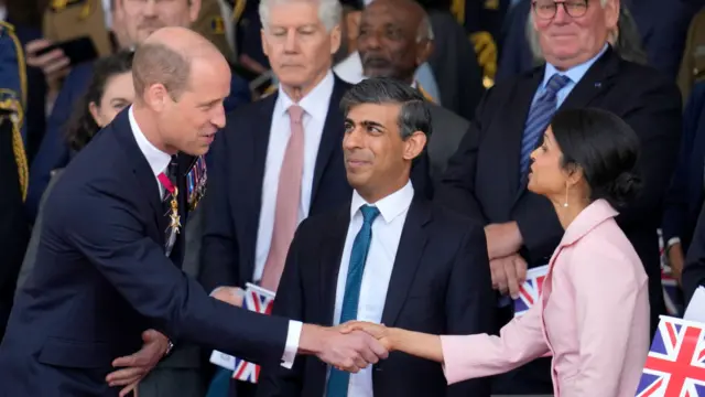 Prince William shakes hands with Akshata Murty while Rishi Sunak looks on