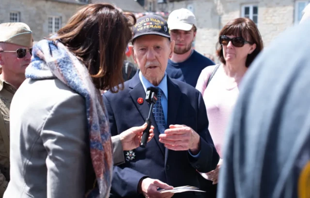 US veteran Donald Cobb speaking to the BBC's Katya Adler - he is and older man wearing a baseball cap and suit