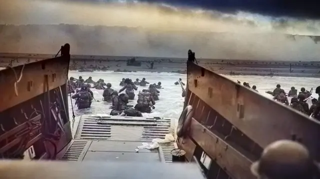 Colourtised archive image of soldiers disembarking from landing craft